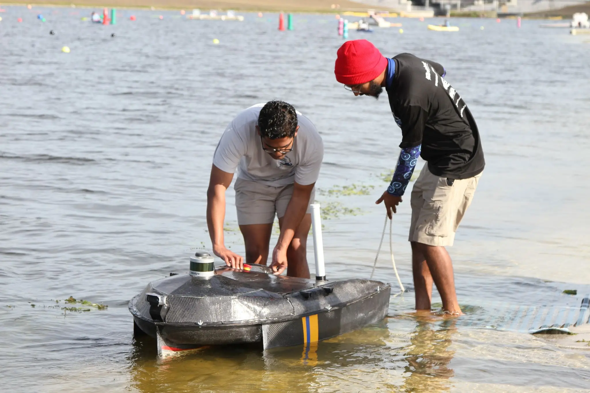 Asheya Naik works on UM::Autonomy's boat, the Phoenix, at the 2023 RoboBoat competition